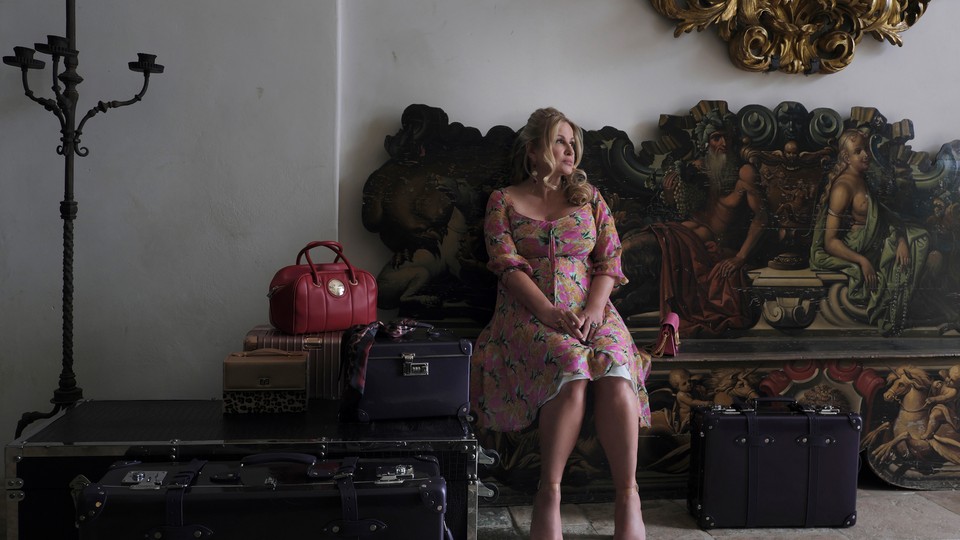 Jennifer Coolidge's Tanya sits surrounded by her luggage in a scene from "The White Lotus"