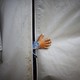 A refugee boy from the Syrian town of Kobani sticks his hand out of a tent in a refugee camp.