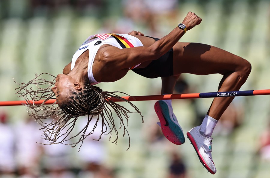 An athlete jumps over a high-jump bar during a competition.