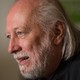 Photograph, in profile, of an older, balding man with a beard and chin-length gray hair.