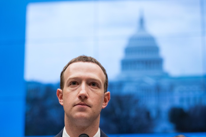 Mark Zuckerberg looks ahead in front of an image of Capitol Hill