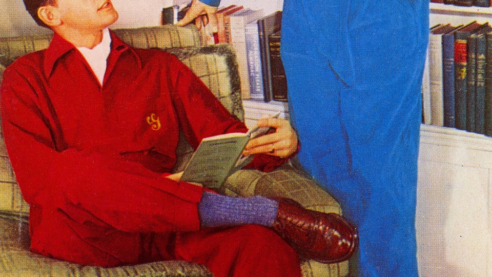 A reading boy looks up at a man