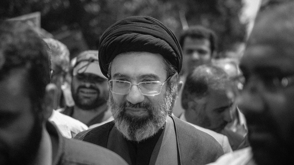 Black and white photograph of Mojtaba Khamenei in a crowd of people.