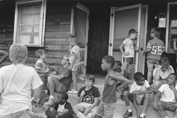 Kids hanging out in front of camp cabin