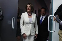 House Minority Leader Nancy Pelosi walks out of a building.