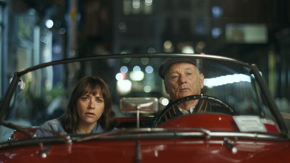 Rashida Jones and Bill Murray in a red roadster