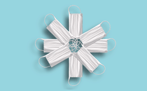 White surgical masks arranged in the shape of a snowflake