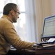 A man checks his email on his desktop computer.