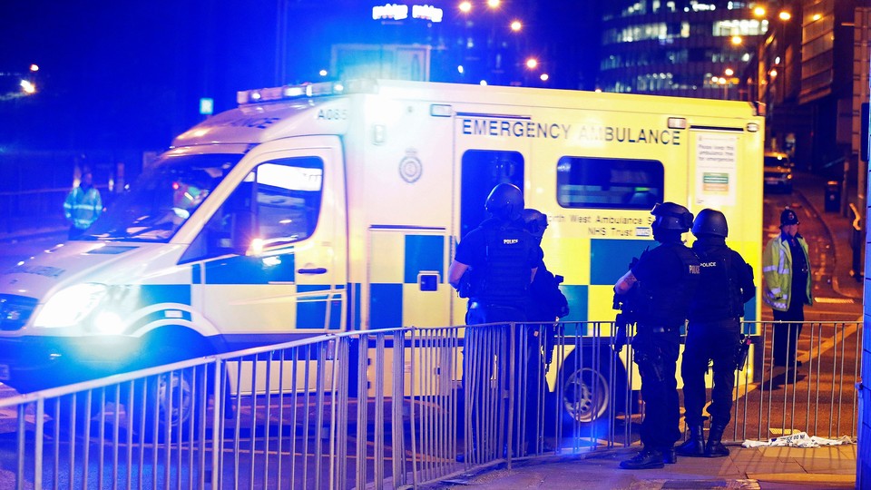 Armed police officers stand near the Manchester Arena.