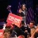 Rep. Elise Stefanik waves to the crowd, and a supporter holds up a "Trump Will Fix It" sign