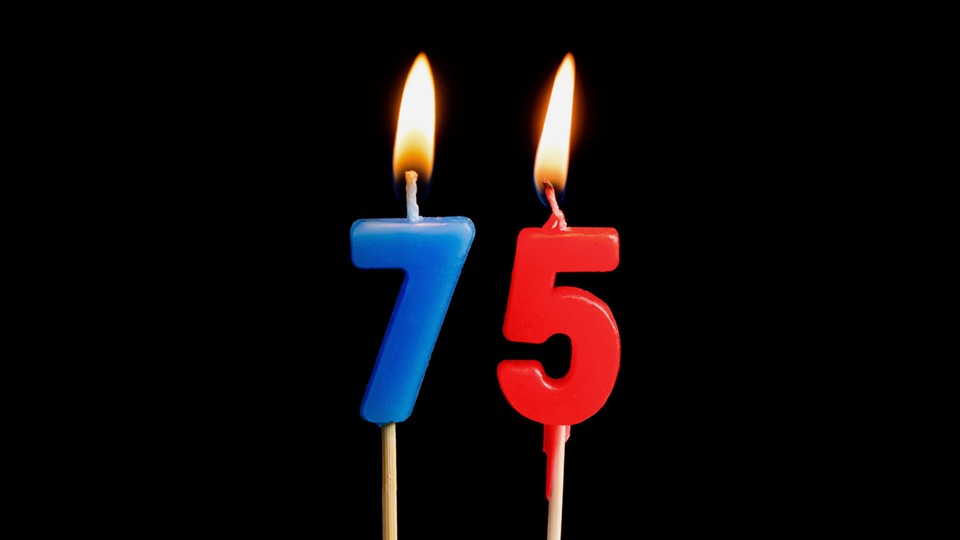 two birthday candles, a blue seven and a red five, are lit with high flames.