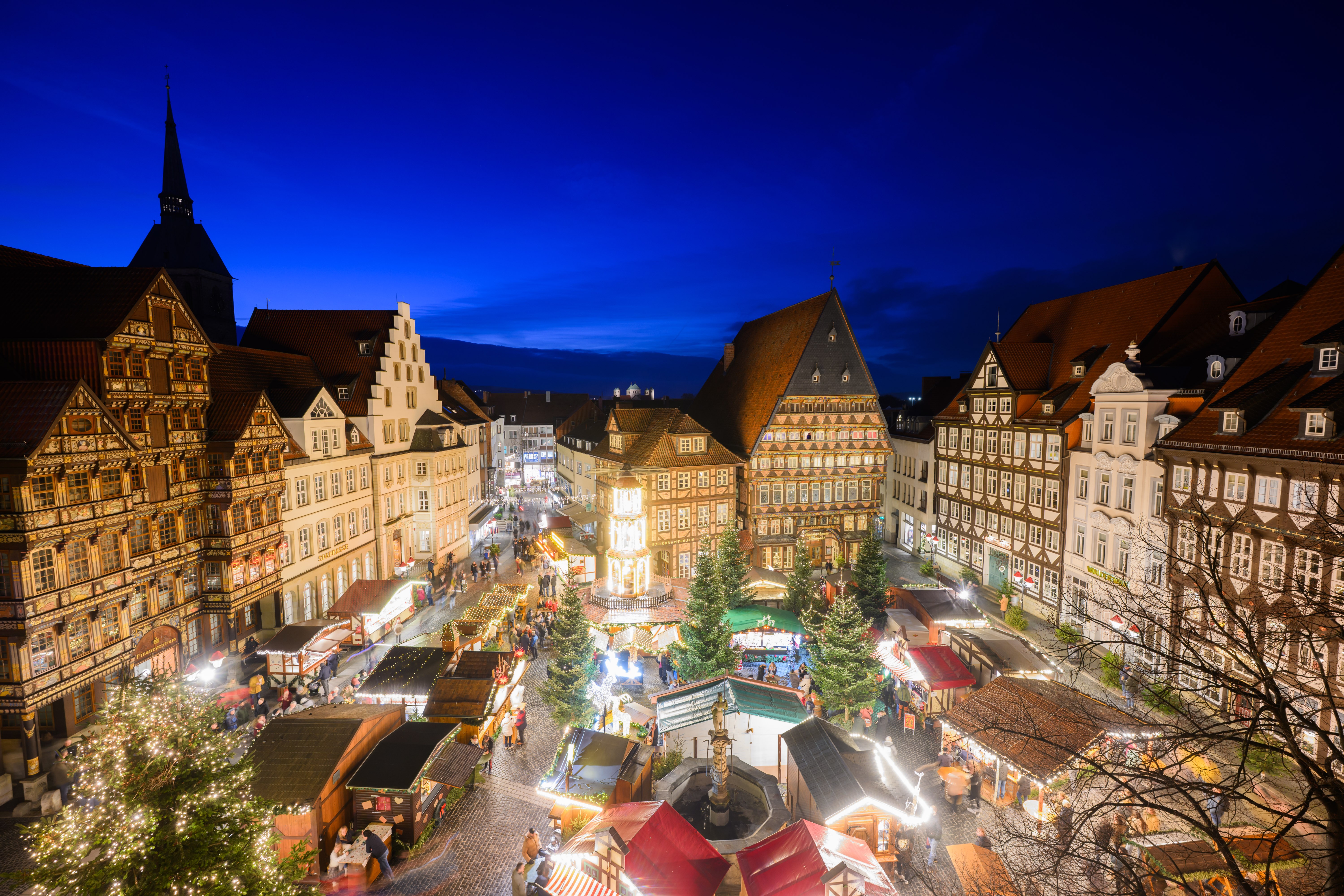 Lights shine in a small town square in Germany for a Christmas market.