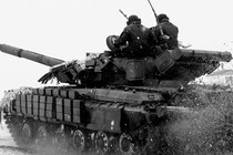 Two people sit atop a tank in Ukraine in 2022.