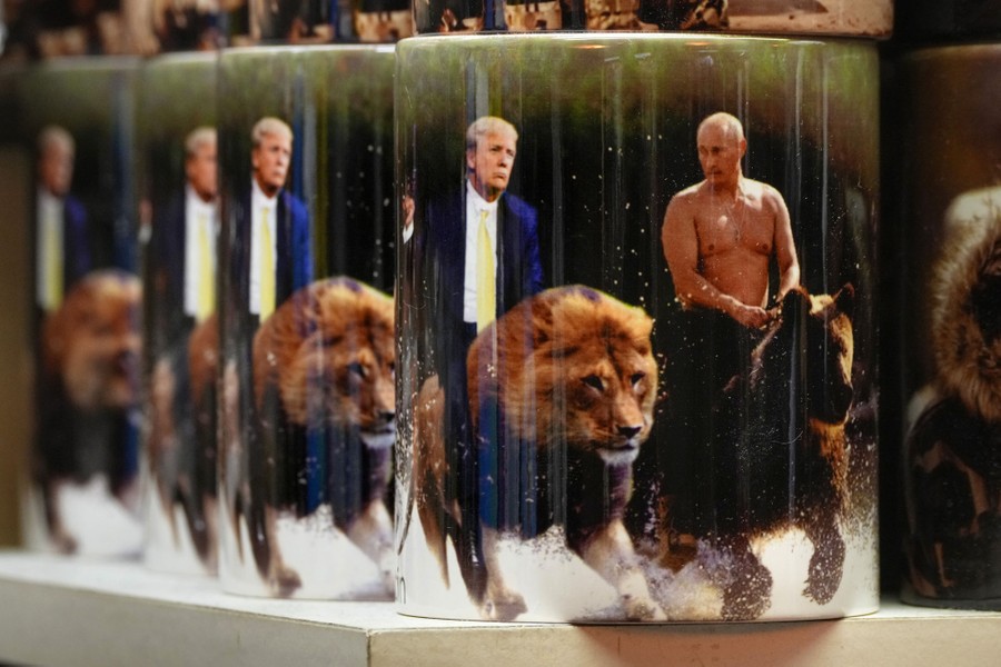 Several souvenir cups, printed with a manipulated photo composition depicting Vladimir Putin riding a bear beside Donald Trump riding a lion.