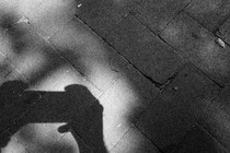 Photograph of a shadow of hands holding a smartphone