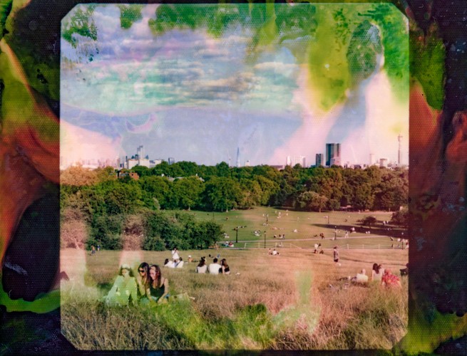 People relaxing in small groups in a park