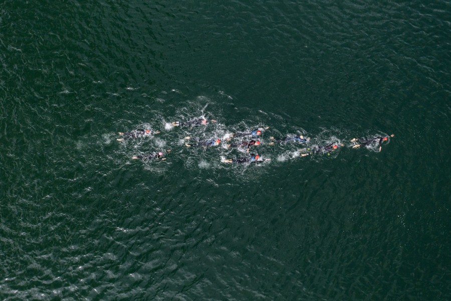 An aerial view of a group of athletes swimming in a lake