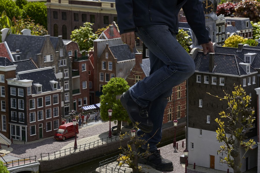 A person walks among miniature buildings.