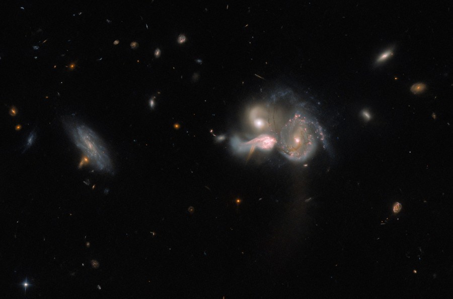 Three swirling galaxies are seen in relatively close proximity in deep space.