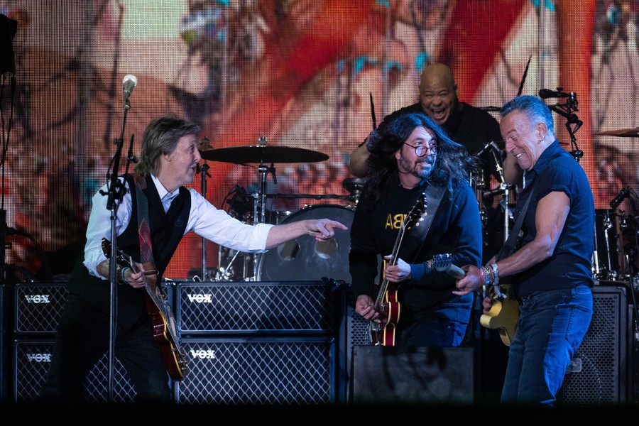 Artists Paul McCartney, Dave Grohl, and Bruce Springsteen perform together.