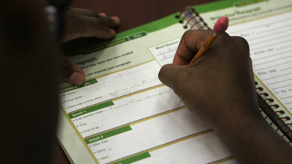 A student fills out pages in a reading workbook.