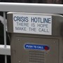 A metal box with a red button that says "push to call," and a placard reading "Crisis Hotline. There is hope make the call"
