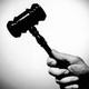A hand holding a gavel
