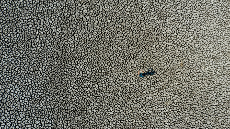 An aerial view of a cracked, dry lake bed