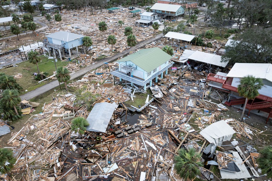 A drone view shows a damaged neighborhood littered with debris, following a hurricane.