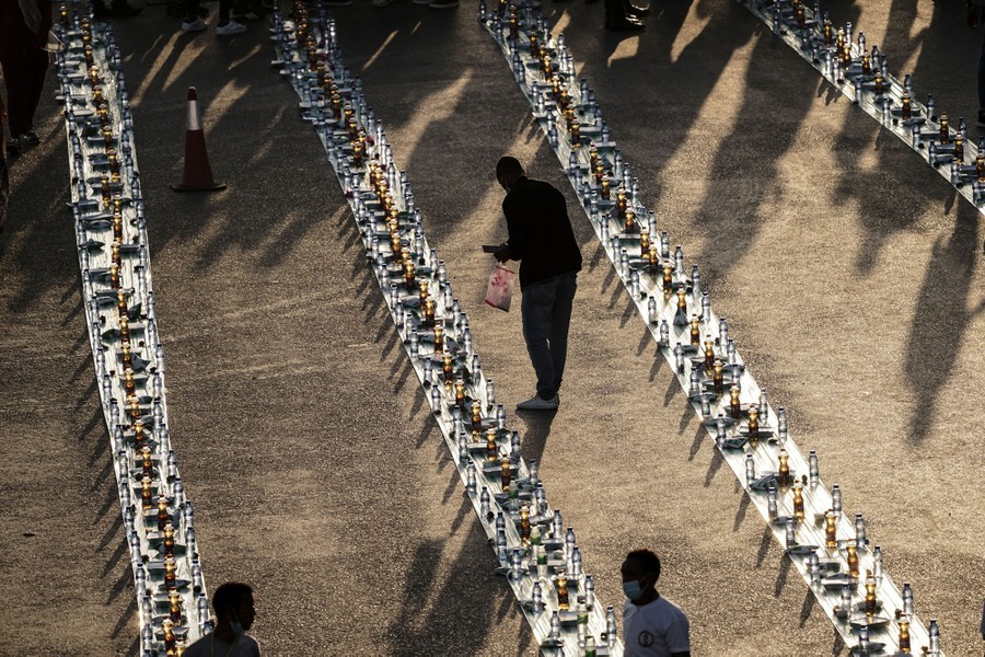 A person distributes drinks along long lines of dishes.