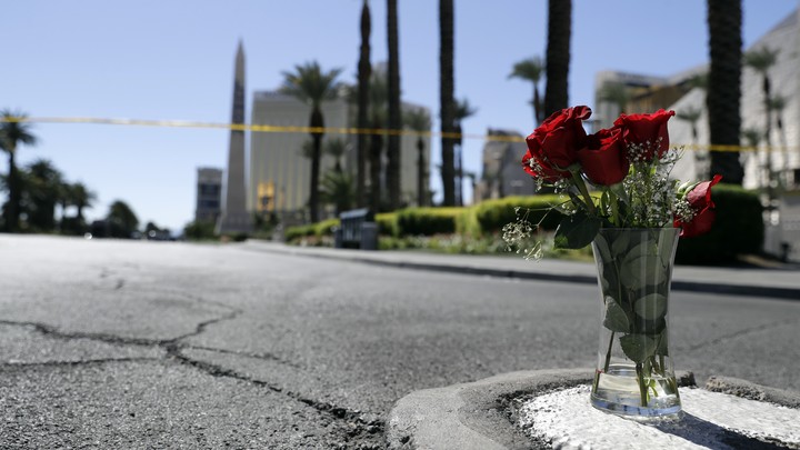 A vase of roses on a sidewalk