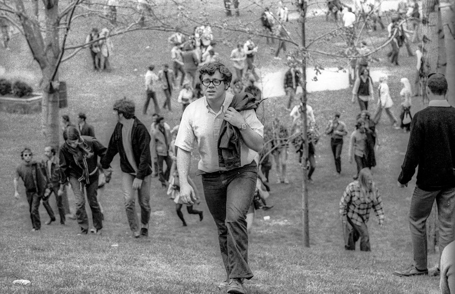 Protesters spread out and leave, walking up a hill.