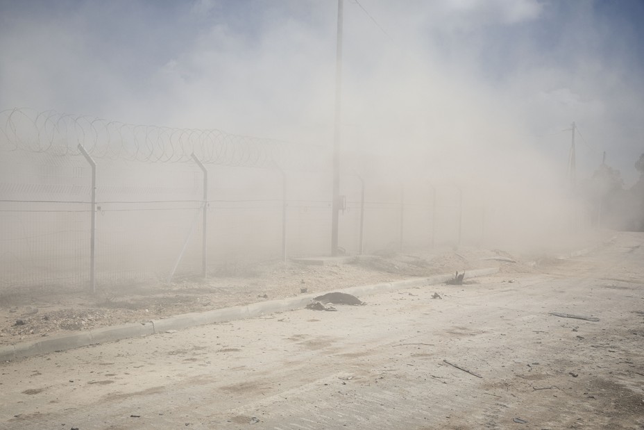 Dust blowing around a fence at Kibbutz Be'eri