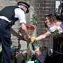 People leave flowers at a makeshift memorial where a man drove a van into Muslims outside a mosque in London.