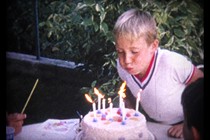 A boy blowing out candles on a birthday cake