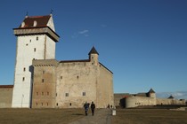 Visitors walk on the grounds of Narva's Hermann Castle, which is separated from Russia's Ivangorod Fortress behind it by the Narva River.