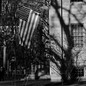 Black-and-white picture of American flag hanging from college building