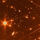 A test image taken by the James Webb Space Telescope that shows a few bright stars and many galaxies in the background