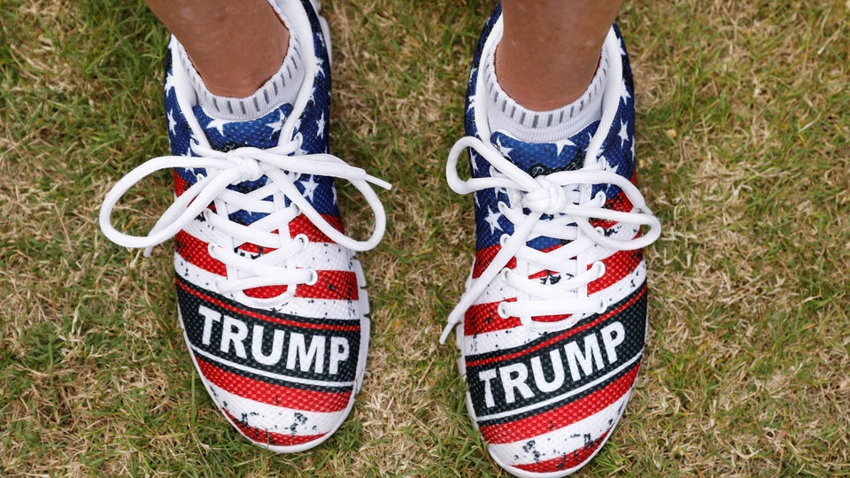 A close-up of shoes monogrammed with "Trump" and an American flag