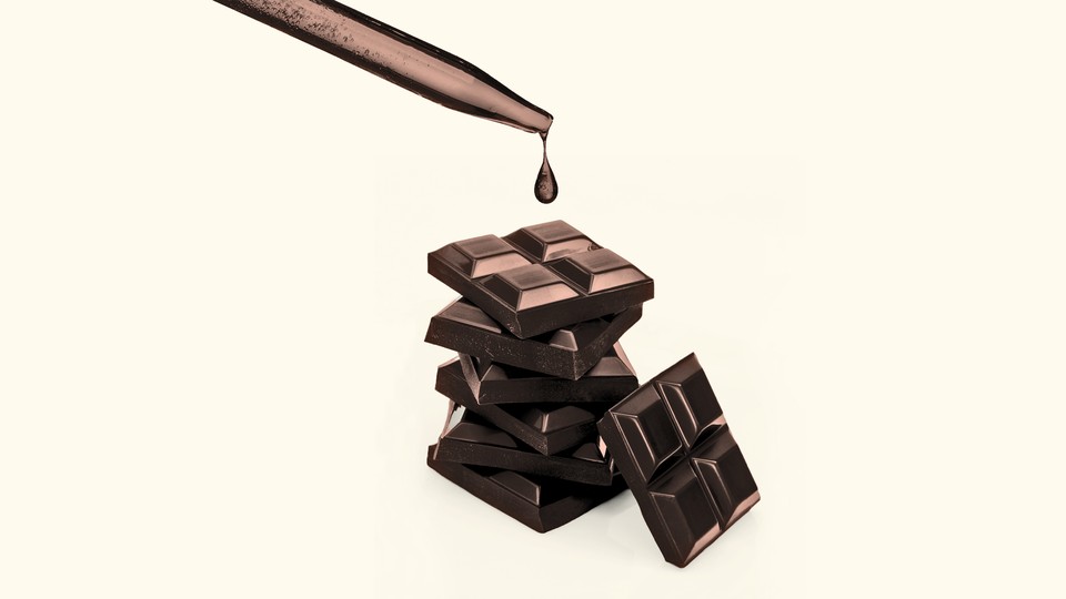 An image of chocolate squares with a lab dropper above them.