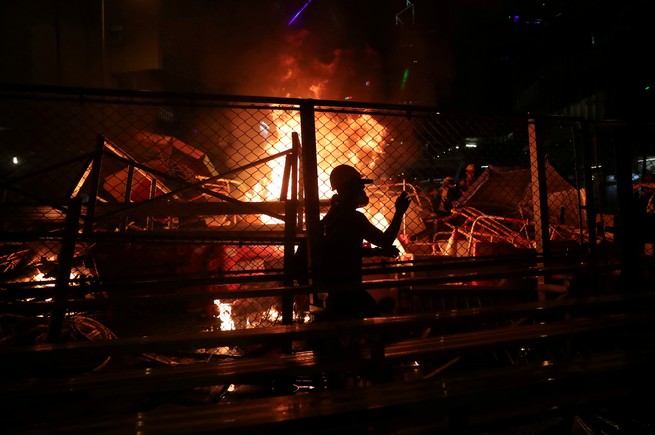 A demonstrator walks past a burning barricade during a protest in Hong Kong.