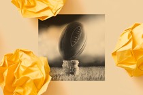 A black-and-white photo of a football resting on top of a pile of casino chips