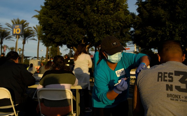 A nurse injects a vaccine dose into someone's shoulder