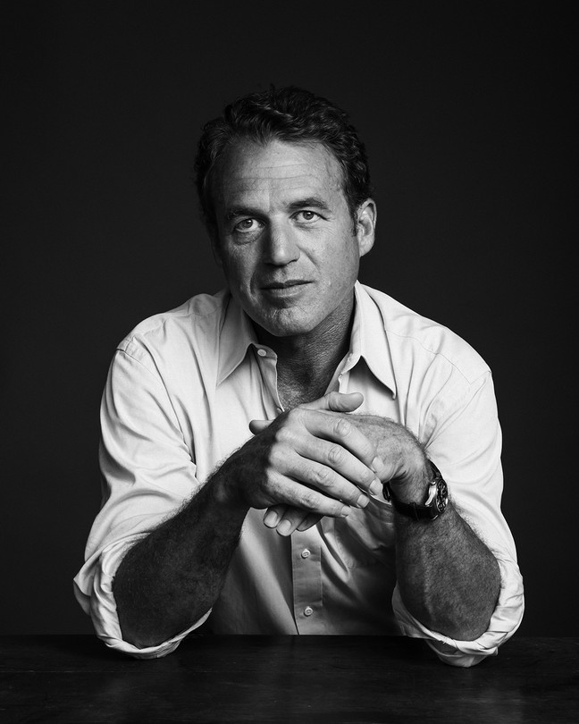 A black-and-white photograph of William Langewiesche wearing a white shirt and seated at a desk