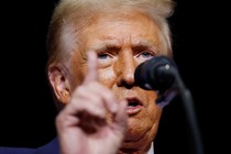 A close-up photo of Donald Trump in front of a microphone