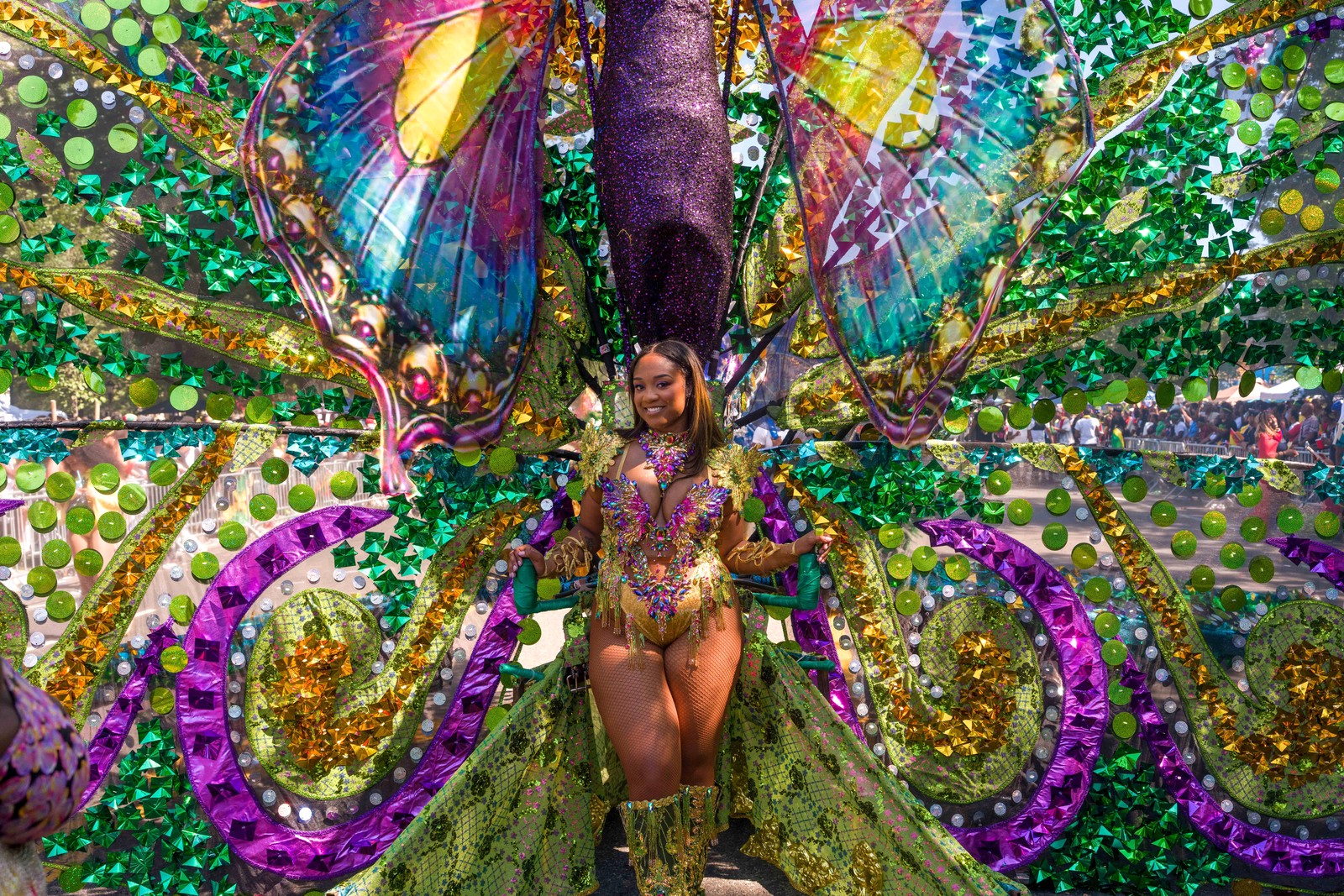 A person wears a giant butterfly costume during a parade.