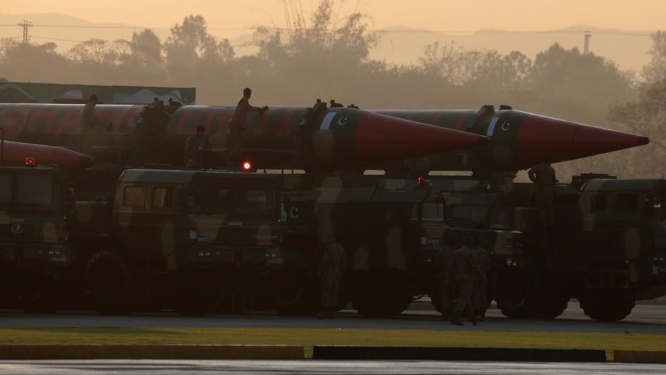Workers cleaning missiles on transports