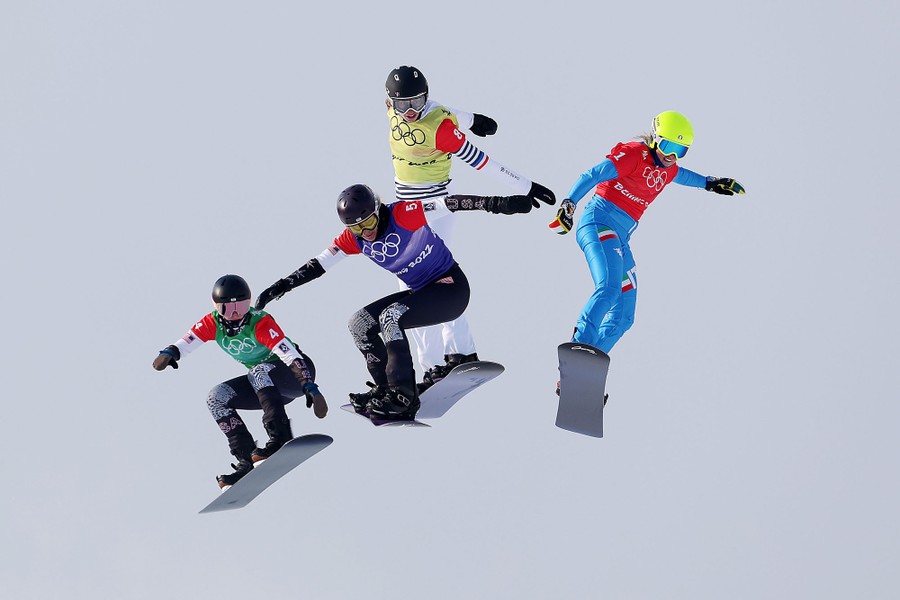 Four snowboarders are seen in mid-air during a race.