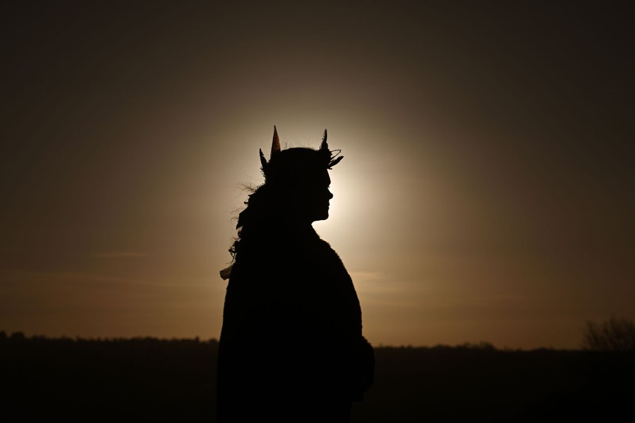 A person is silhouetted by the rising sun.