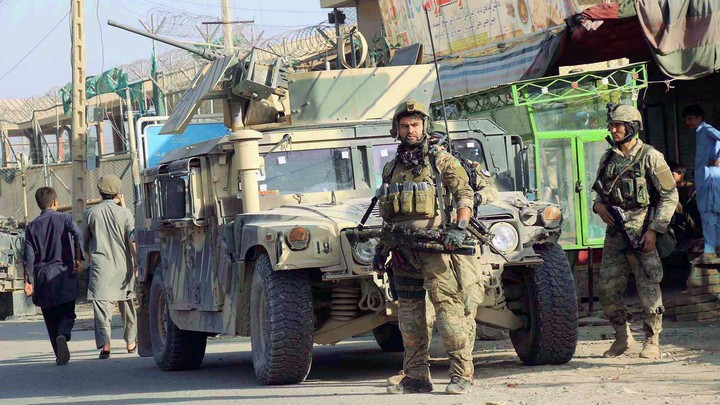 Afghan security forces keep watch in front of their armoured vehicle in Kunduz, Afghanistan, on Tuesday.